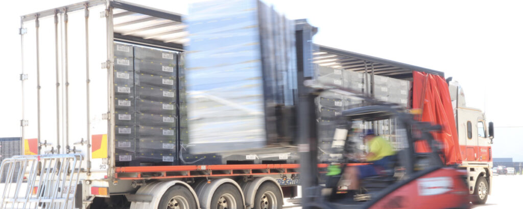 Forklift carrying Coles' smart bins that are used to digitalise their supply chain