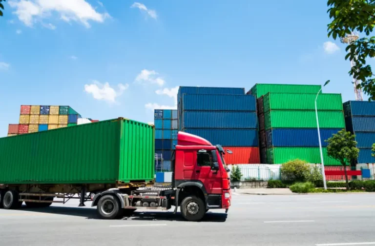 Trailer on the road in front of shipping containers. All the assets are tracked by an IoT supply chain management solution for fleet tracking in Australia