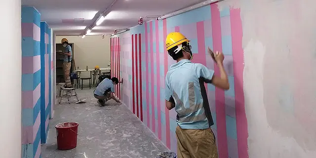 Two people painting the walls of a property that uses IoT property and facility management in Hong Kong.