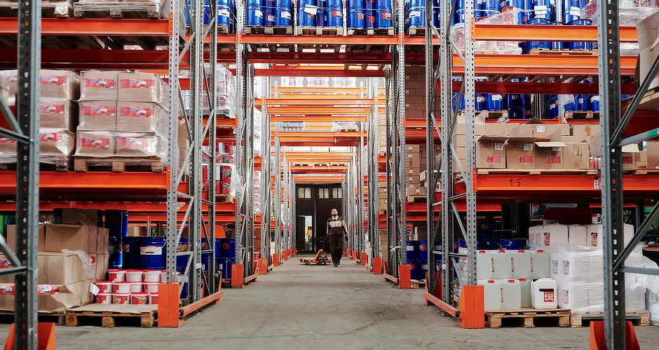 Person walking in a warehouse that uses asset tracking solutions to improve the ROI in supply chain