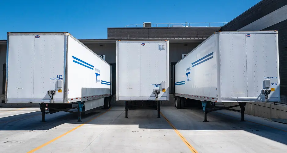 Three industrial trailers parked while using asset tracking devices that help to improve the ROI in supply chain