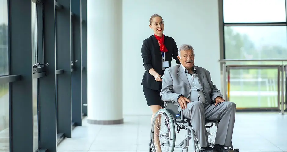 Person pushing a wheelchair at the airport. The wheelchair uses a tracking system to locate it easily.